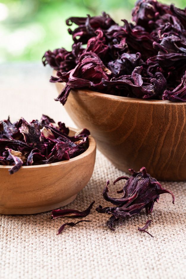 Vibrant dried Nigerian hibiscus calyx in wooden bowl